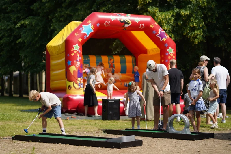 Børn spiller minigolf foran hoppeborgen